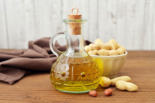 Peanut Oil With Raw Peanuts On Wooden Background Istockphoto 681828534 170667A