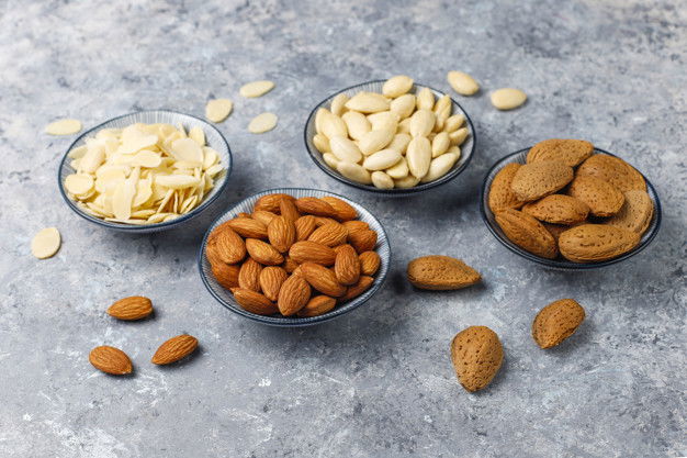 9 Nourishing Almond Oil To Keep Hair Gorgeous 2 Raw Fresh Almonds With Shell Without Shelll Almond Slices Top View 114579 7184