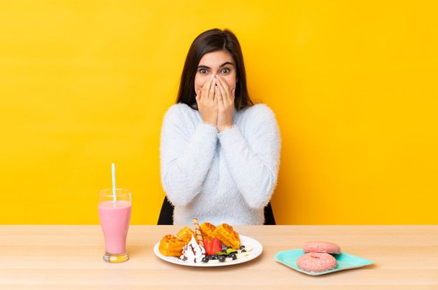 Young Woman Eating Waffles Milkshake Table Isolated Yellow Wall With Surprise Facial Expression 1368 141093