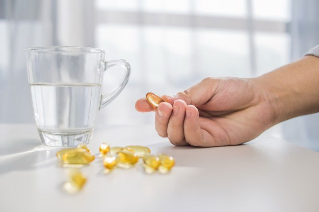 Healthy Lifestyle Medicine Nutritional Supplements People Concept Close Up Male Hands Holding Pills With Cod Liver Oil Capsules Water Glass 1088 1054
