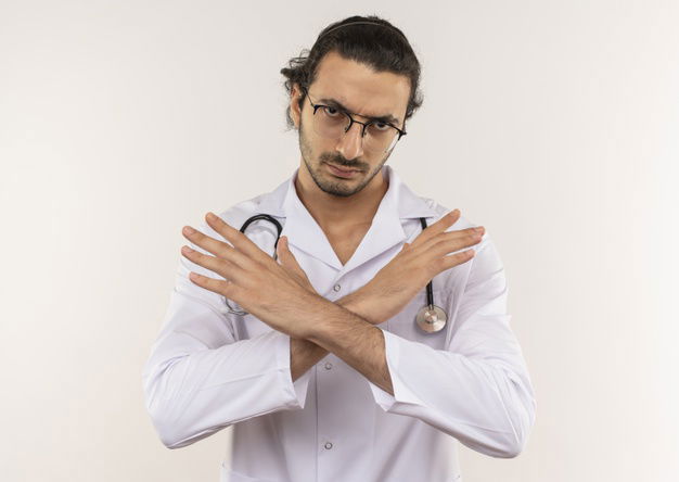 Strict Young Male Doctor With Optical Glasses Wearing White Robe With Stethoscope Showing Gesture No Isolated White Wall With Copy Space 141793 78211