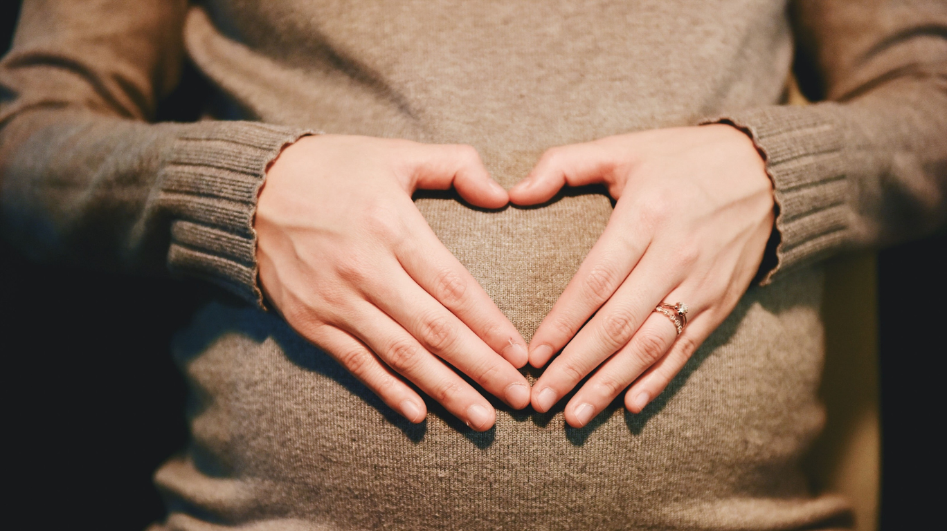  Pregnant Woman Gently Massaging Her Belly With Castor Oil To Encourage Natural Labor