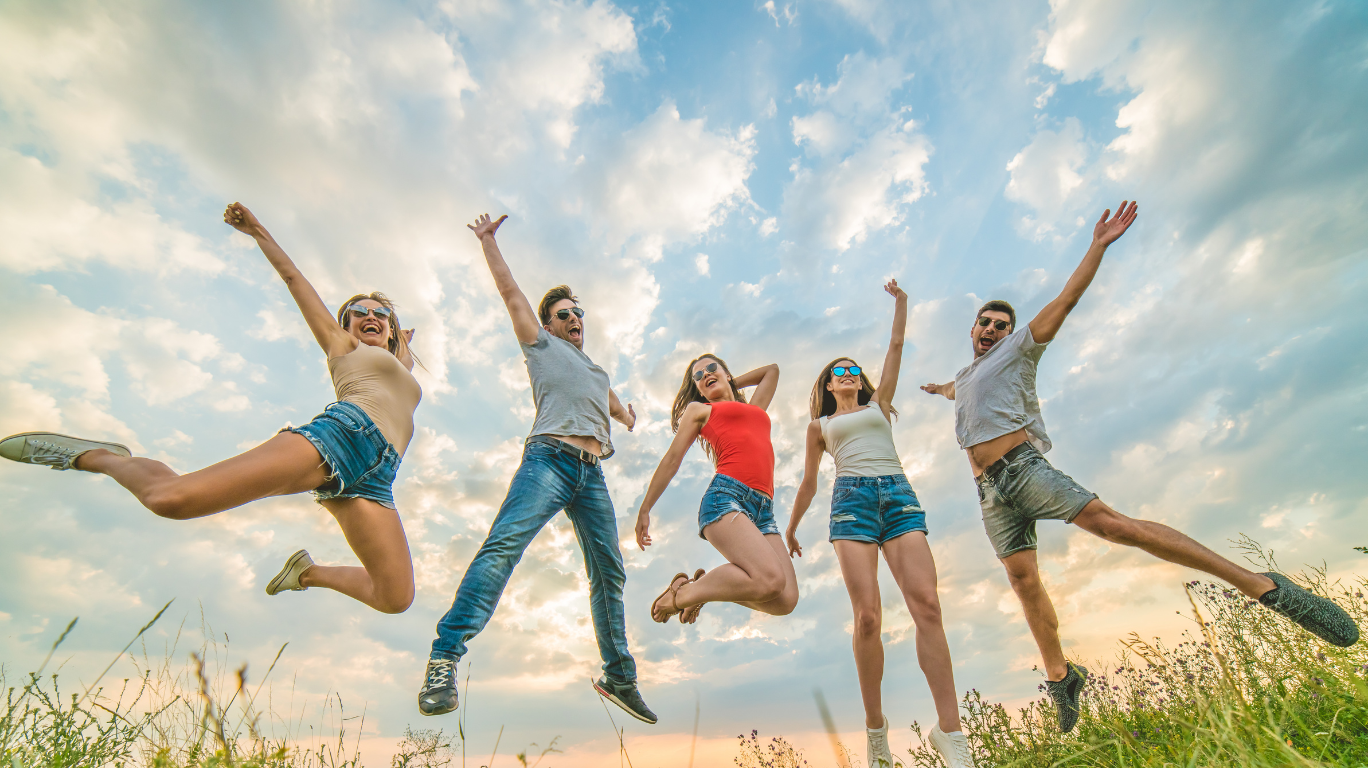 A Diverse Group Of Young People Smiling And Laughing Together Outdoors On A Sunny Day